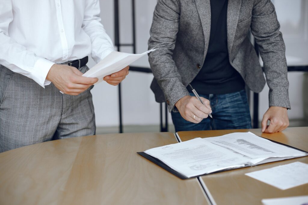 business-men-sitting-lawyers-s-desk-people-signing-important-documents_1157-40454