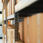 cardboard-boxes-packages-with-merchandise-depot-placed-racks-shelves-before-shipment-distribution-empty-warehouse-space-with-carton-packages-cargo-supplies-handheld-shot_482257-59991