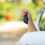girl-sitting-car-holding-car-keys-hands-out-car_1150-51916